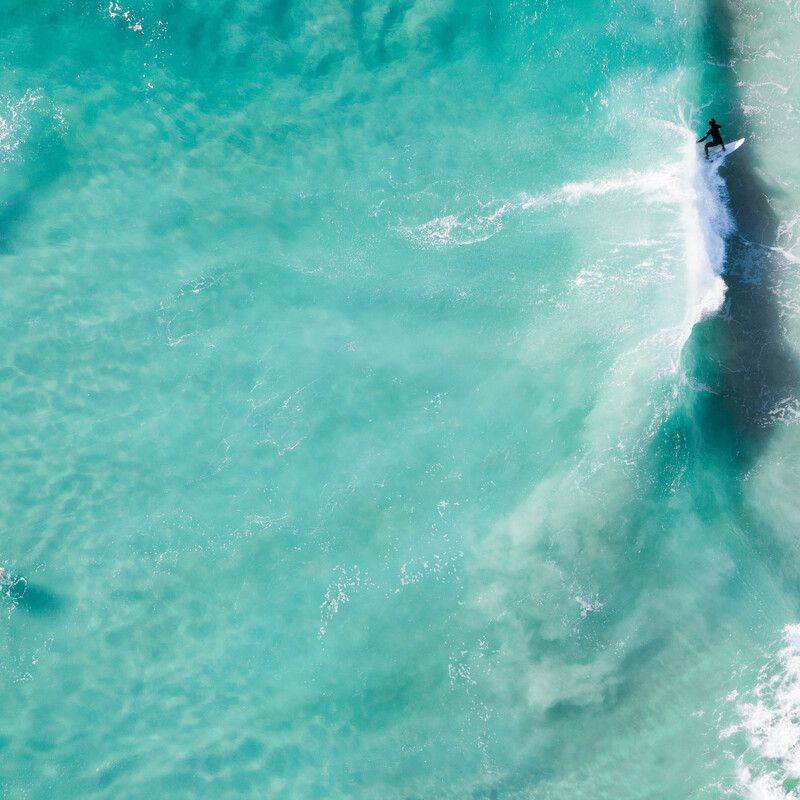 Drei Surfer im Wasser aus der Vogelperspektive